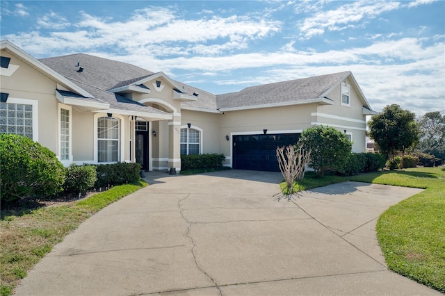 view of front of home with an attached garage, a shingled roof, concrete driveway, and stucco siding