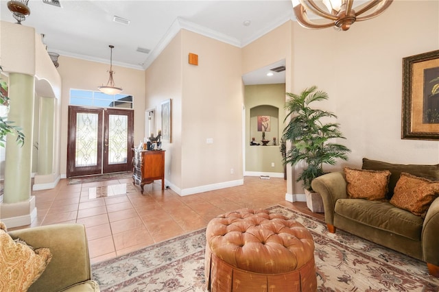 entryway featuring french doors, light tile patterned floors, a high ceiling, ornamental molding, and baseboards