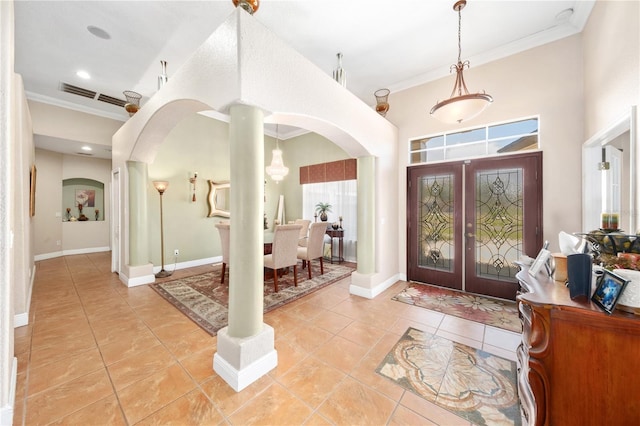 foyer featuring visible vents, arched walkways, crown molding, and light tile patterned flooring