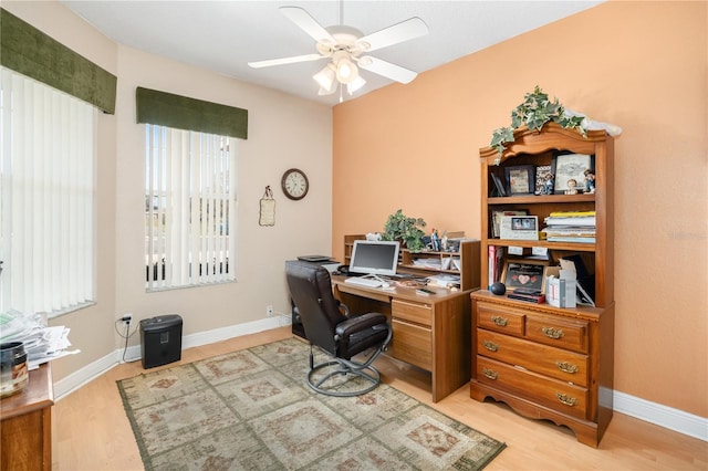 home office featuring light wood finished floors, baseboards, and a ceiling fan