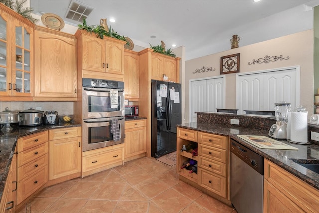 kitchen with visible vents, appliances with stainless steel finishes, dark stone counters, and glass insert cabinets