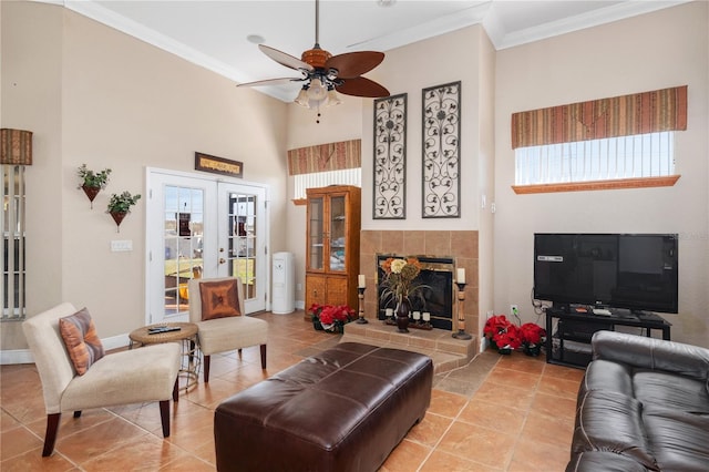 living area with a fireplace, baseboards, crown molding, and french doors