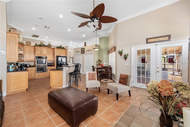 living area with light tile patterned floors, french doors, visible vents, and crown molding