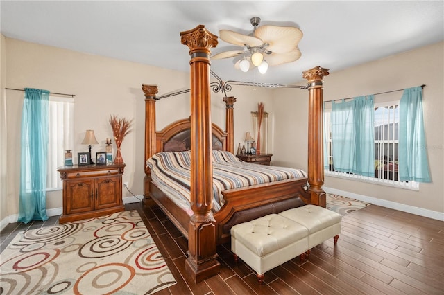 bedroom with dark wood-style flooring, decorative columns, and baseboards