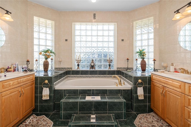 bathroom featuring a bath, two vanities, a sink, and tile walls