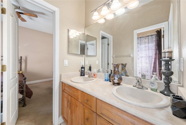 bathroom featuring double vanity, a sink, and baseboards