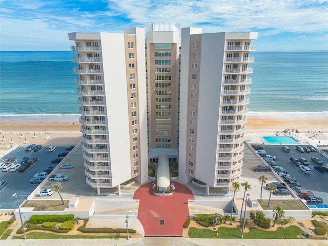 view of property with a beach view and a water view