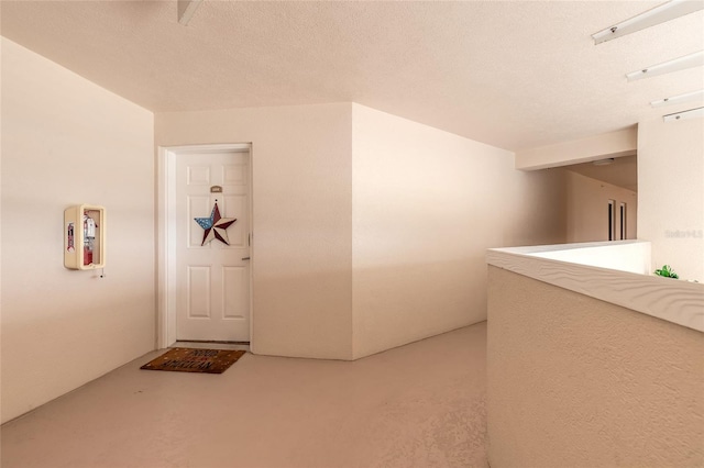 hallway featuring concrete flooring and a textured ceiling