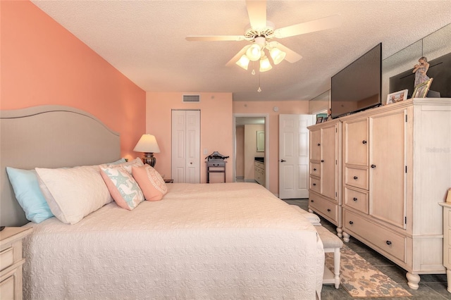 bedroom featuring a textured ceiling, a closet, visible vents, and a ceiling fan