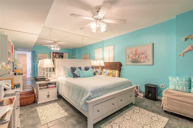 bedroom with ceiling fan and a textured ceiling