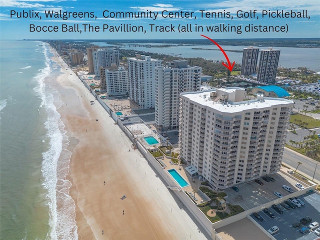 birds eye view of property with a view of city, a water view, and a beach view