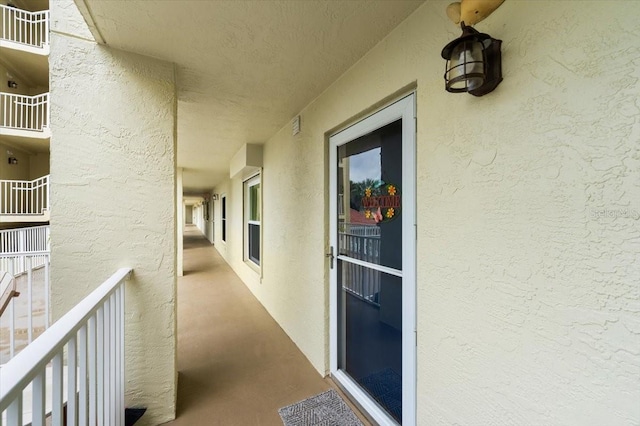 doorway to property with a balcony and stucco siding