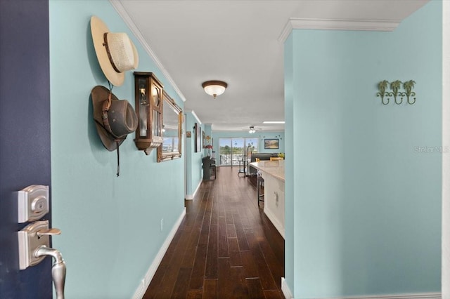 hallway with dark wood-style floors, baseboards, and crown molding