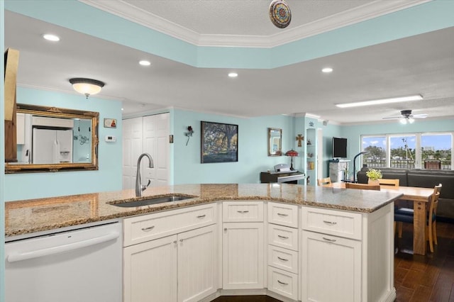 kitchen featuring light stone counters, crown molding, dark wood finished floors, a sink, and white appliances