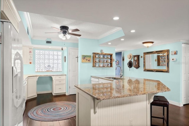 kitchen featuring white fridge with ice dispenser, dark wood-style flooring, a sink, and crown molding