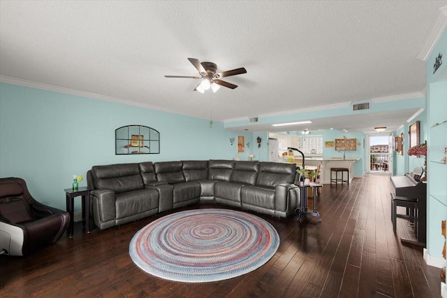 living area with a textured ceiling, hardwood / wood-style floors, visible vents, and crown molding