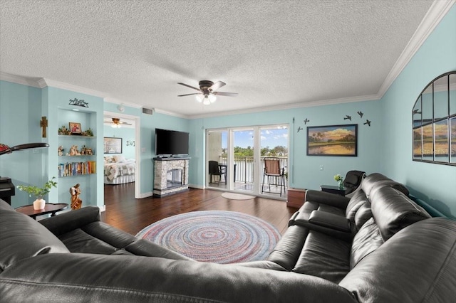 living area featuring a fireplace, crown molding, visible vents, and wood finished floors