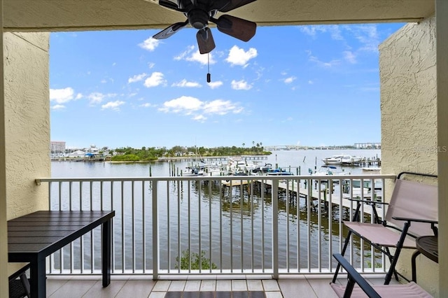 balcony with a water view and a ceiling fan