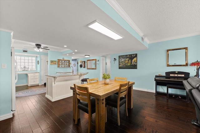 dining area featuring crown molding, recessed lighting, dark wood-type flooring, a textured ceiling, and baseboards