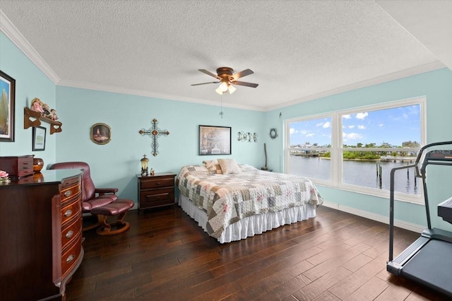 bedroom with ceiling fan, dark wood-style flooring, a water view, crown molding, and a textured ceiling