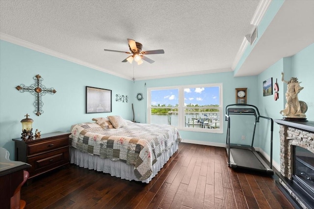 bedroom with dark wood-style floors, visible vents, and ornamental molding