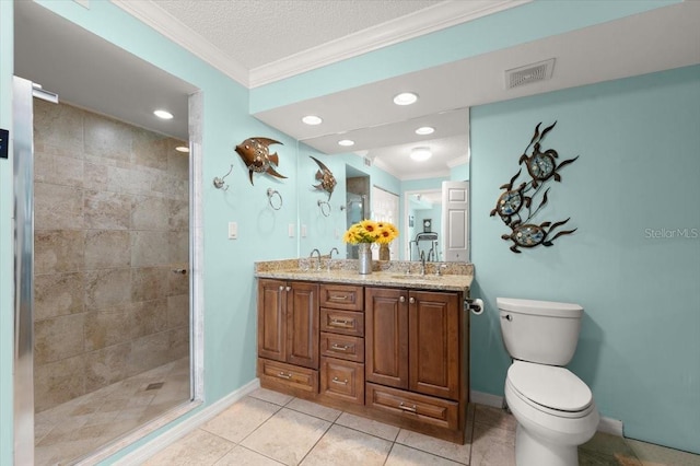 bathroom featuring crown molding, tiled shower, a sink, and toilet