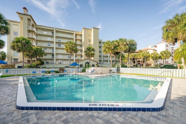 community pool with fence and a patio