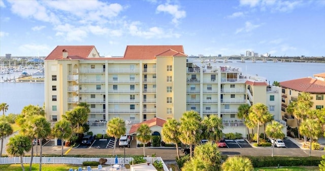 view of property with a water view and uncovered parking