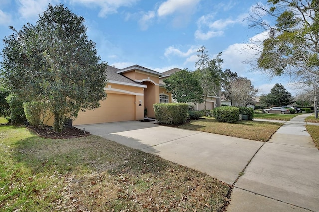 view of front of home featuring driveway, a front lawn, an attached garage, and stucco siding