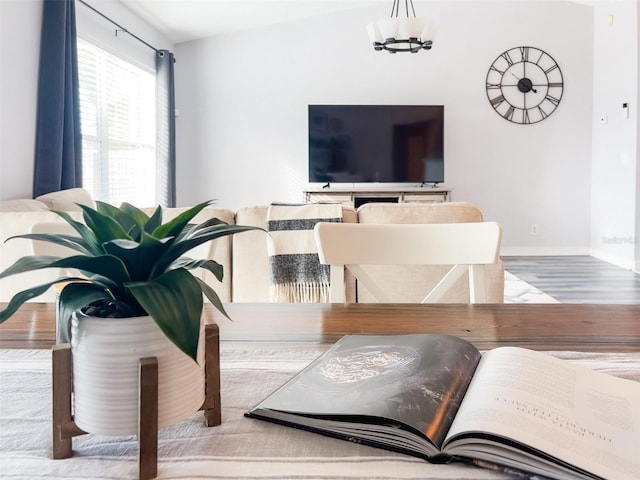 interior space featuring an inviting chandelier, baseboards, and wood finished floors