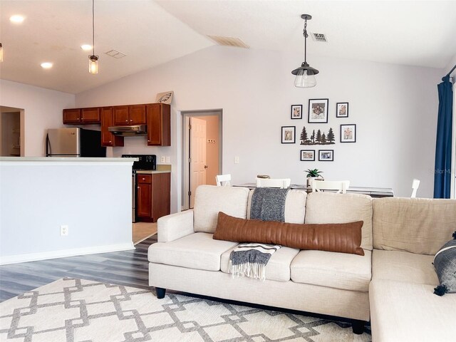 living room with visible vents, vaulted ceiling, and wood finished floors