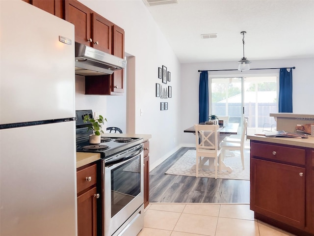 kitchen featuring visible vents, hanging light fixtures, stainless steel appliances, light countertops, and under cabinet range hood