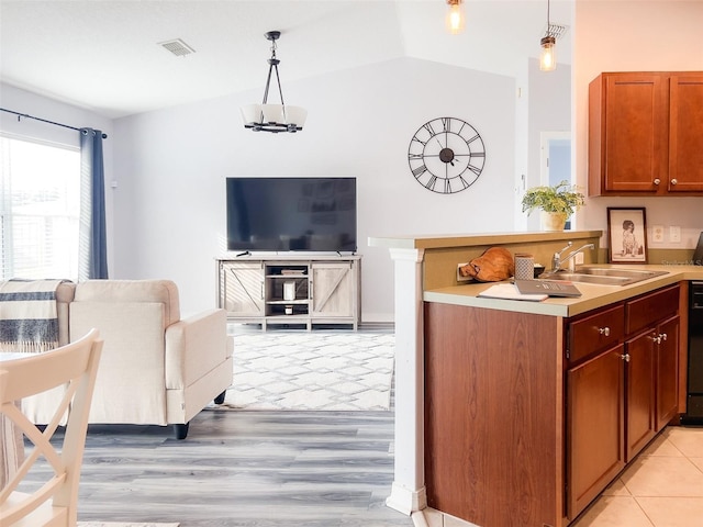 kitchen with hanging light fixtures, visible vents, light countertops, and a sink