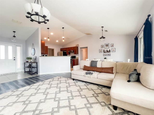 living room featuring lofted ceiling, wood finished floors, and visible vents