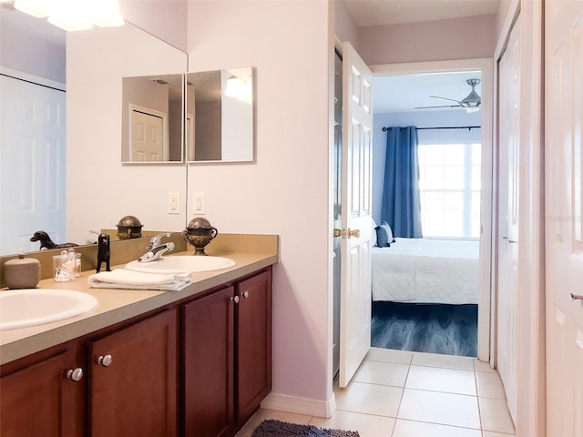 ensuite bathroom with ceiling fan, connected bathroom, a sink, tile patterned floors, and double vanity