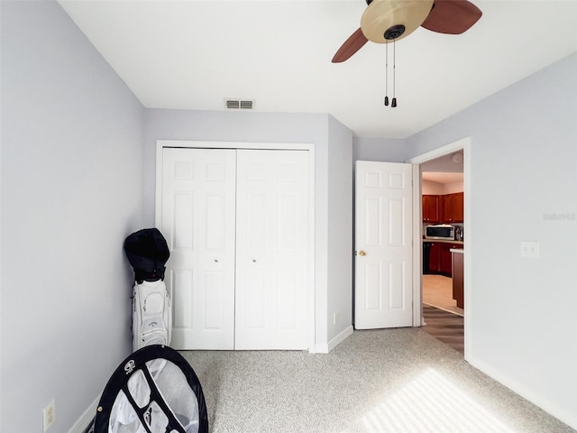 unfurnished bedroom with carpet, a closet, visible vents, a ceiling fan, and baseboards