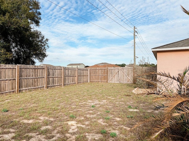 view of yard with a gate and a fenced backyard