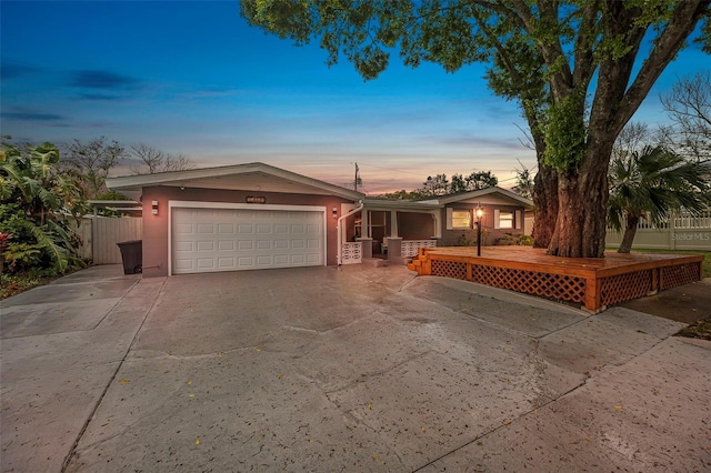 single story home featuring a garage, driveway, and fence