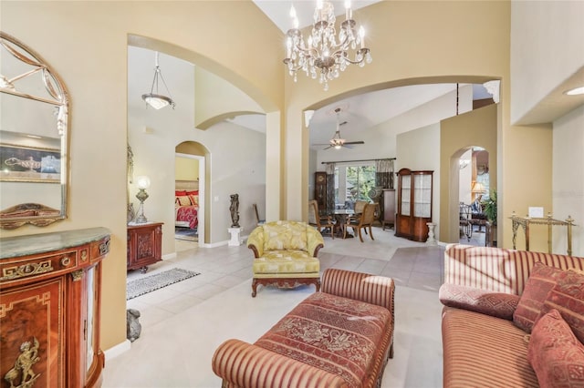 tiled living room with arched walkways, baseboards, a high ceiling, and ceiling fan