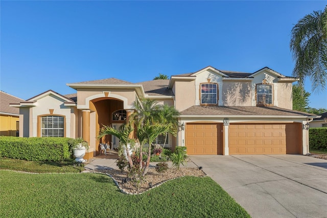 view of front of home featuring an attached garage, driveway, and stucco siding