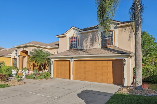 view of front of home with a garage, driveway, and stucco siding