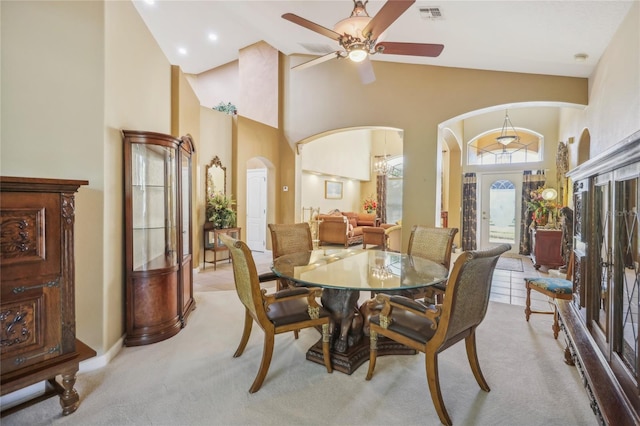 dining room featuring light colored carpet, visible vents, arched walkways, and ceiling fan