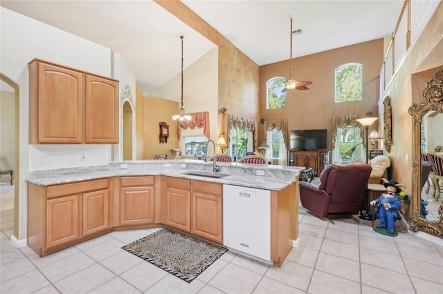 kitchen with light stone countertops, open floor plan, an inviting chandelier, white dishwasher, and a sink