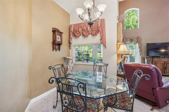 dining space featuring baseboards, a chandelier, and tile patterned flooring