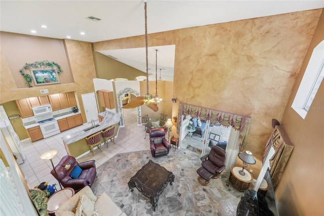 living room with visible vents, recessed lighting, and high vaulted ceiling