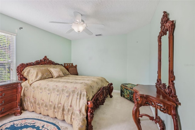 bedroom featuring visible vents, a textured ceiling, ceiling fan, and carpet flooring