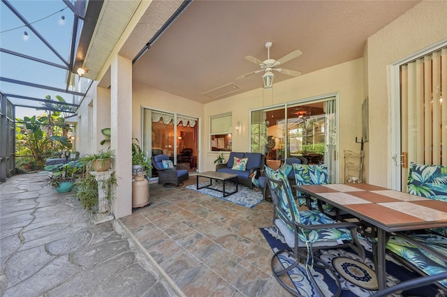 view of patio / terrace featuring an outdoor living space, a lanai, a ceiling fan, and outdoor dining space