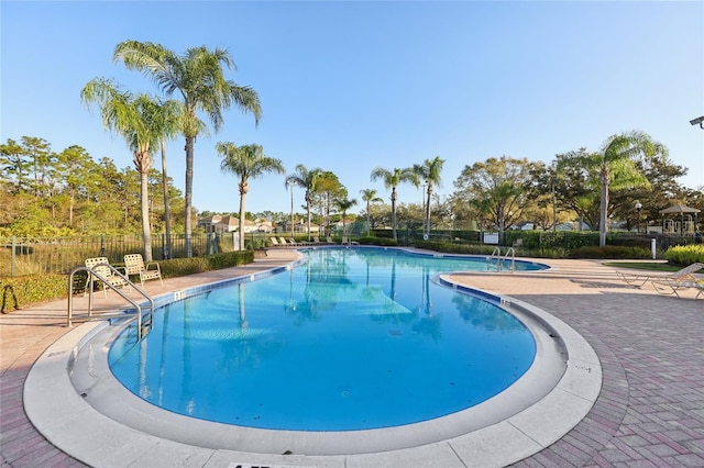 community pool featuring a patio and fence