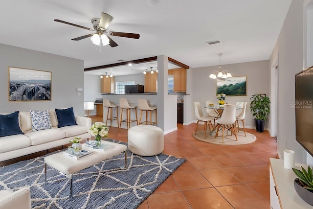 living area with light tile patterned floors, ceiling fan with notable chandelier, visible vents, and baseboards