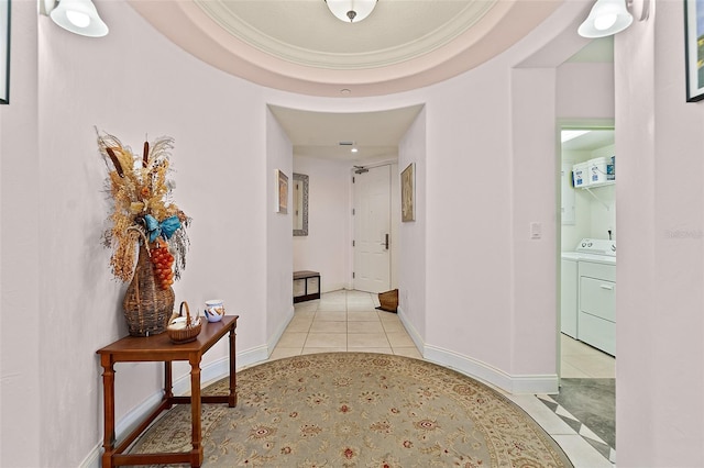 hallway featuring light tile patterned floors, independent washer and dryer, and baseboards